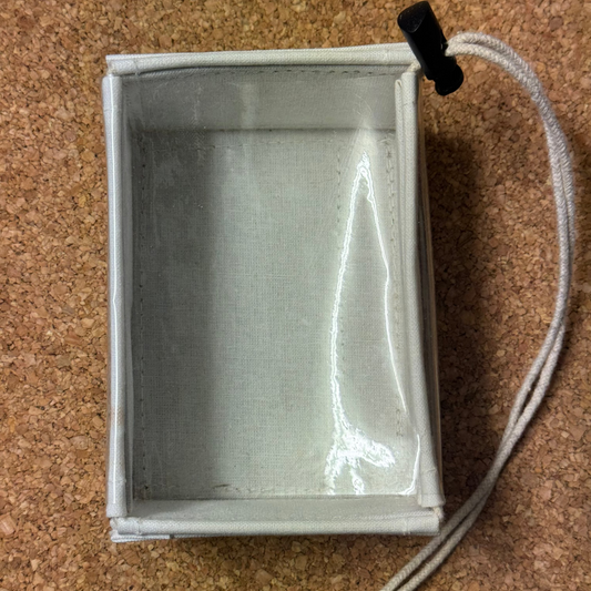 Small rectangular box with a white interior on a cork surface