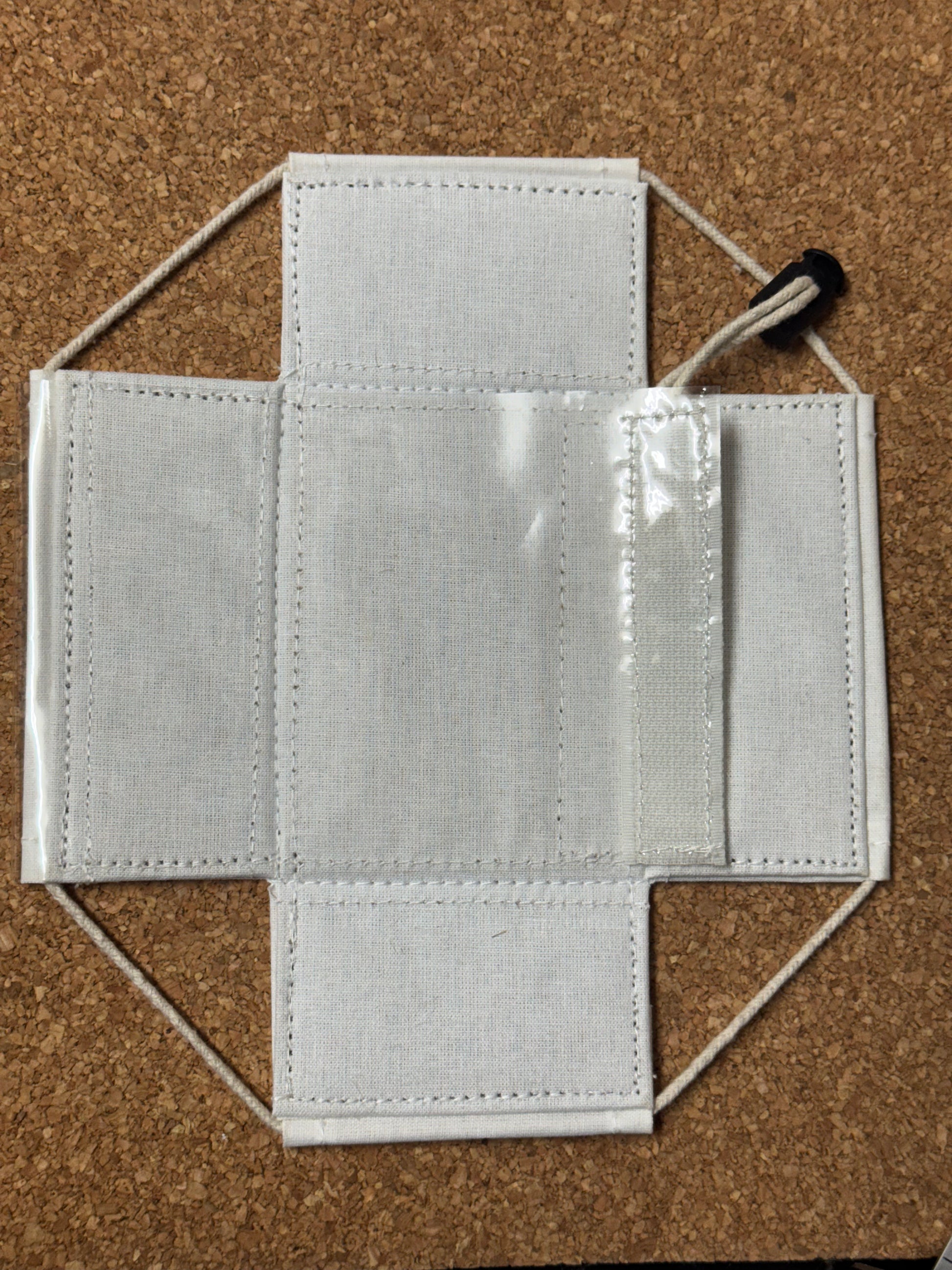 Gray fabric face mask on a cork background