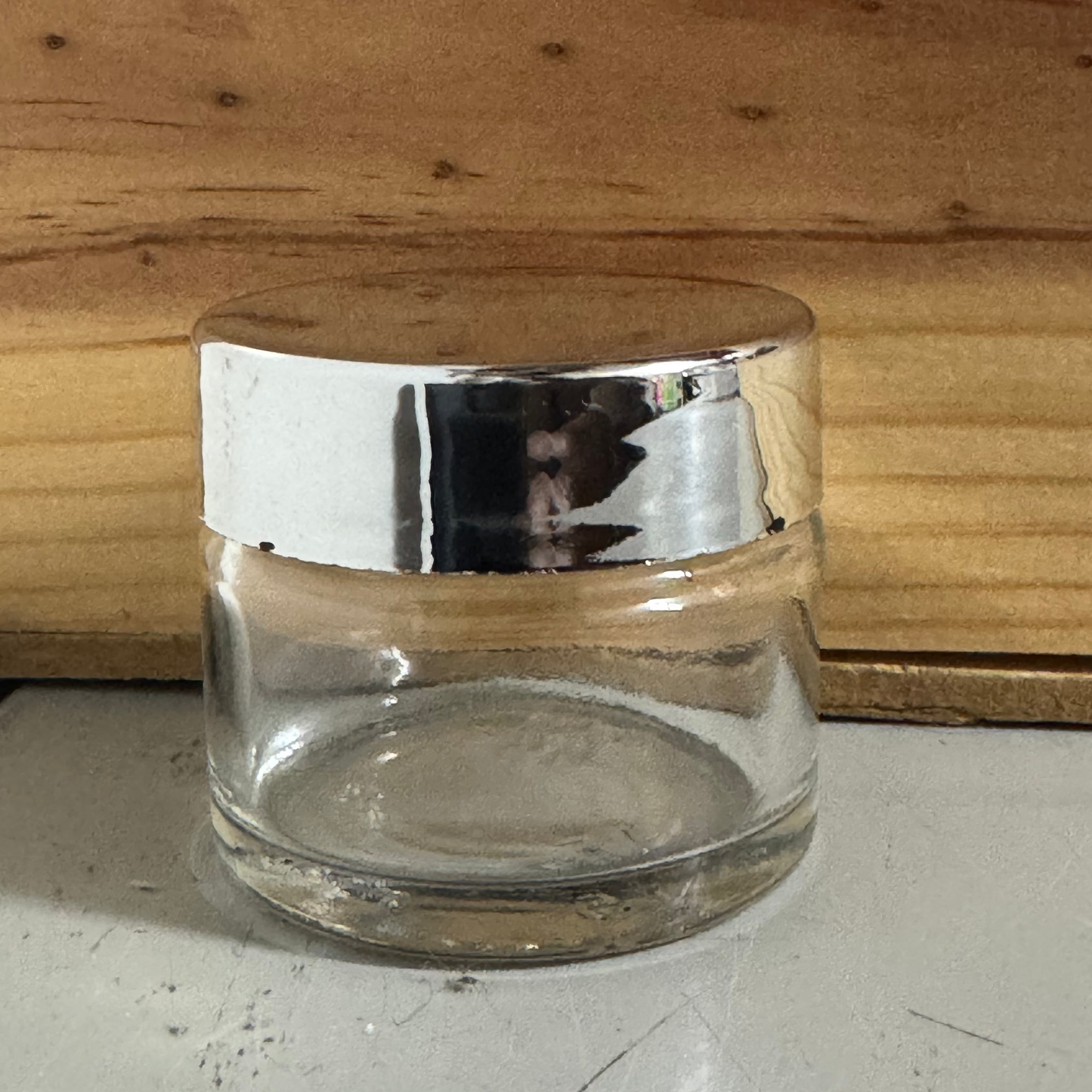 Clear glass jar with a metallic lid on a wooden surface