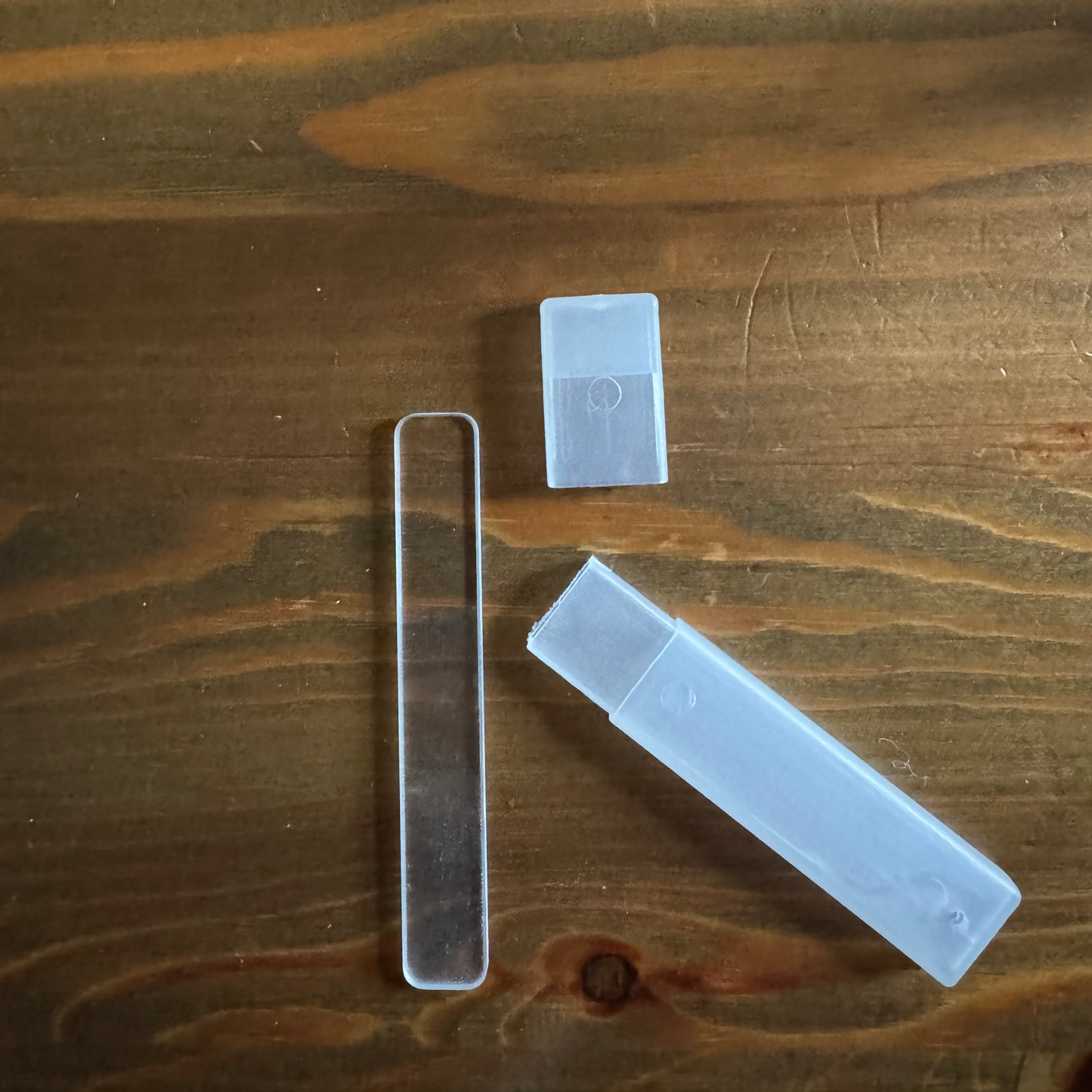 Three clear plastic items on a wooden surface