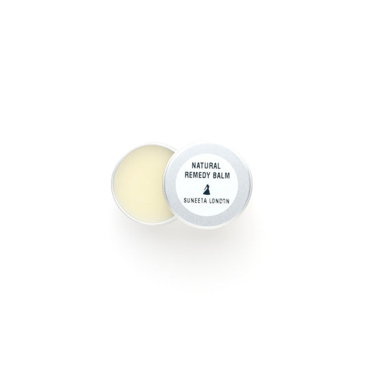 Round natural remedy balm with a white container on a white background